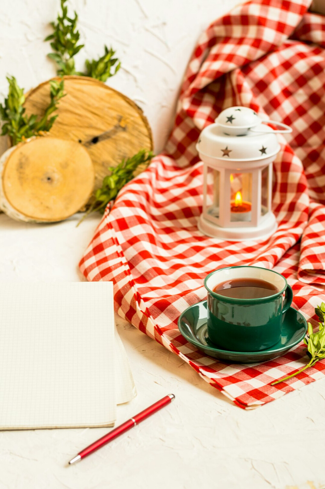 Quiet writing desk with open notebook, warm lamp and cup of tea