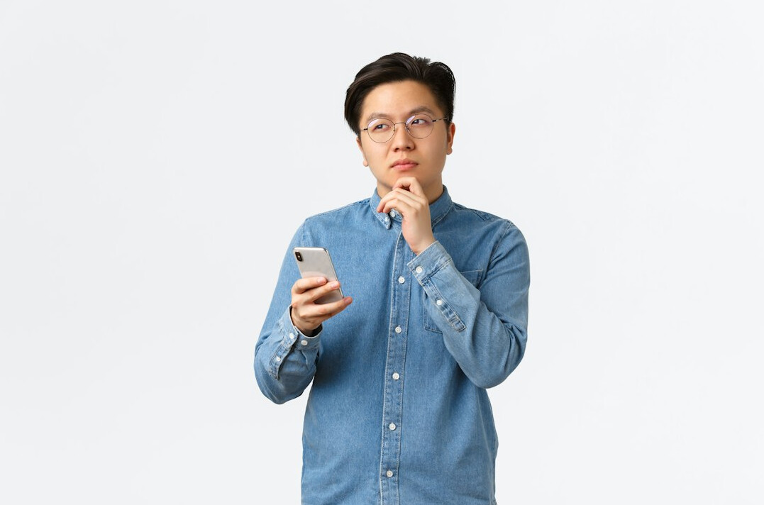person using smartphone thoughtfully